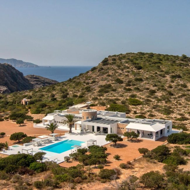 Tagomago villa and pool among Mediterranean vegetation, with the sea beyond