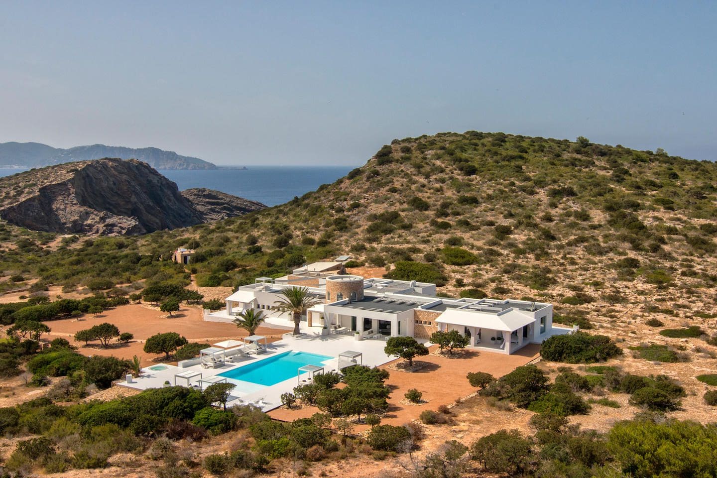 Tagomago villa and pool among Mediterranean vegetation, with the sea beyond