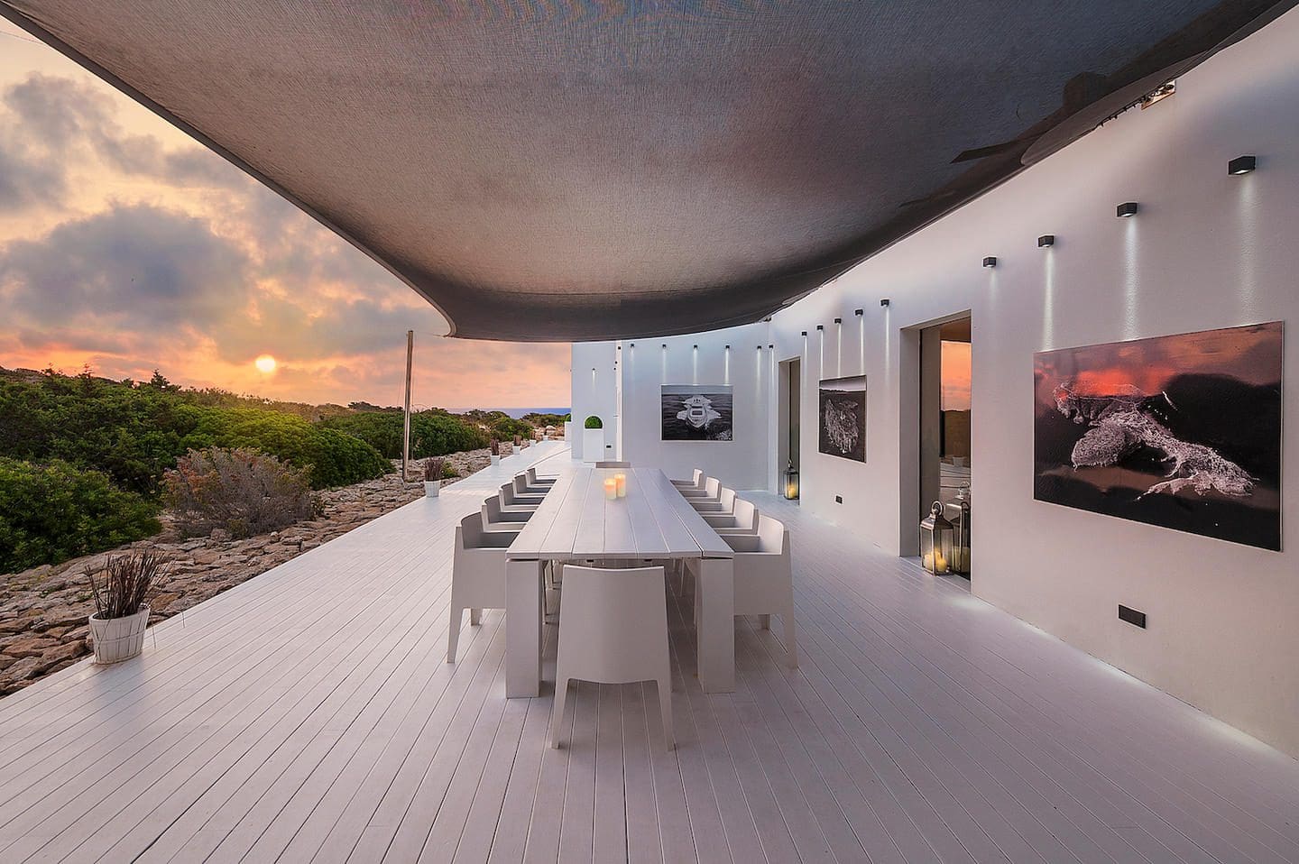 Covered dining terrace at the Tagomago villa overlooking island vegetation at sunset