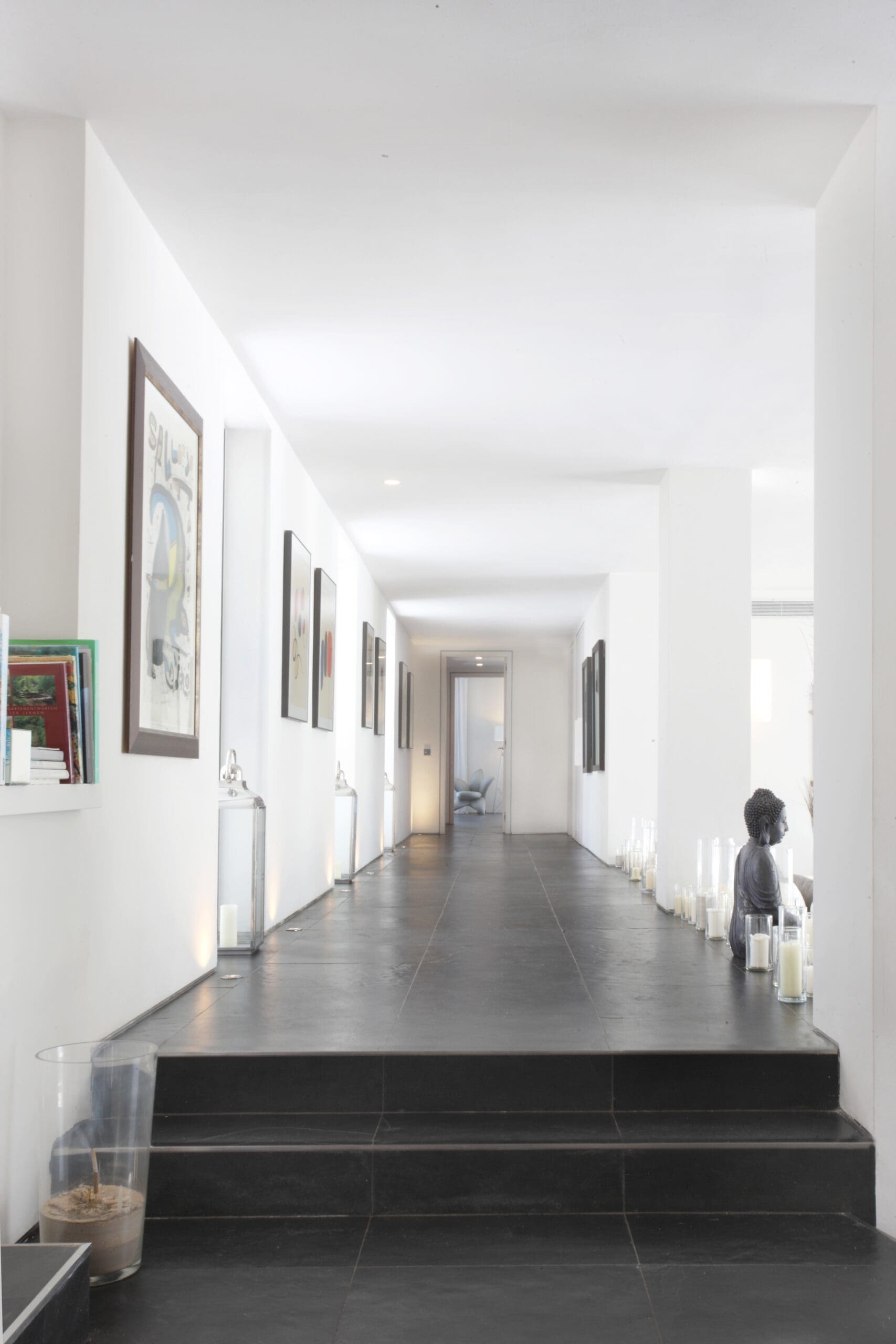 Steps leading into a bright white hallway inside the Tagomago villa