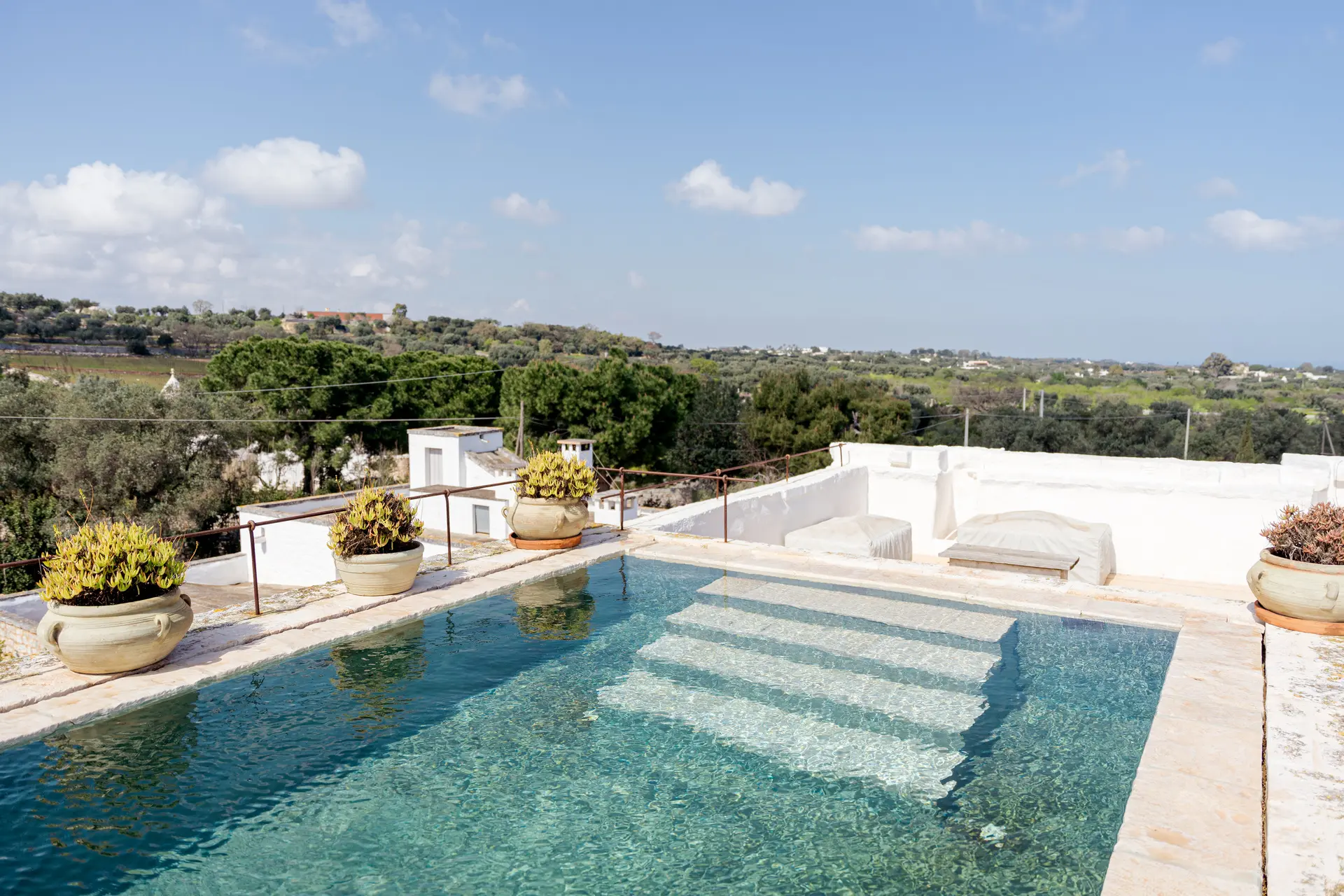 Rooftop pool at Masseria Petrarolo with shallow steps and olive countryside beyond